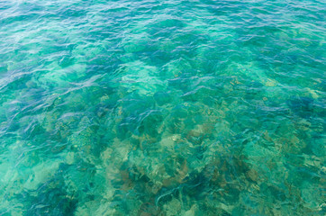 Fototapeta na wymiar closeup beautiful clear blue sea water on the beach paradise ocean. vacation background on summer in Thailand coast.