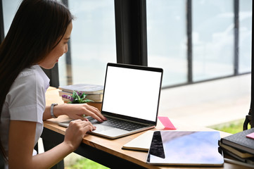Young woman working with mockup laptop computer.