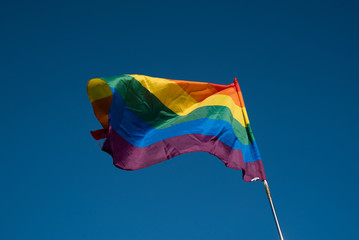 LGTBQ Flag on the blue sky. Rainbow flag over the Barcelona during Pride parade.