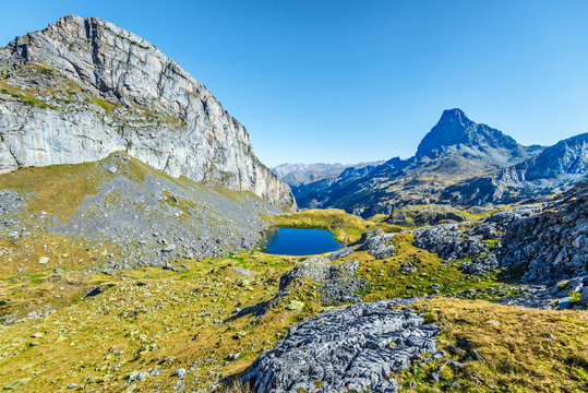 View at Casterau Mountain at left and Casterau lake in French Atlantic Pyrenees, as seen in October.  Ossau peak  is at background.
