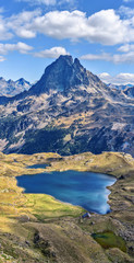 Vertical panoramic view at Midi Ossau mountain peak and Lake Gentau from the mountain pass Ayous in Franch Atlantic Pyrenees, as seen in October. Aquitaine, France.