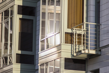 Glazed balcony and large panoramic windows of apartments in a new modern residential area. Urbanism and new architecture. Exterior and facade of the business center, corporate building.