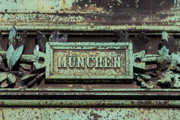 Fototapeta na wymiar Schriftzug München auf altem Hinweisschild als Wegweiser zur Landeshauptstadt von Bayern