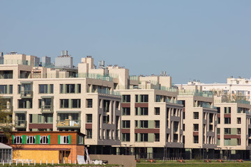 Fototapeta premium Residential area mid-rise buildings. Houses at the embankment of the river near a large green park. Advertising new modern residential buildings. Urbanism. Residential complex near Yelagin island.