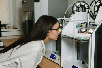 The young girl student printing on a 3D printer