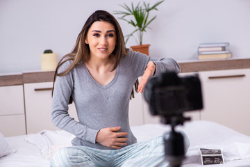 Pregnant woman recording video for her blog 