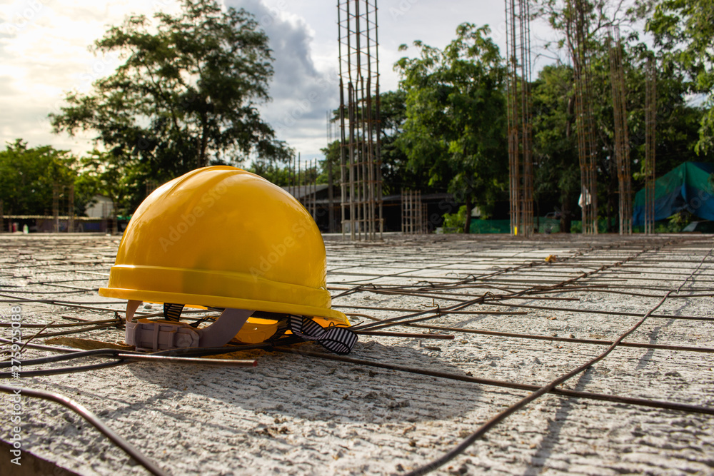 Wall mural security concept, yellow helmet hat for worker safety is an engineer or worker on a concrete floor i