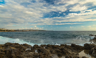 coast of Crete Greece early morning, dawn, pink clouds and waves in foreground.
