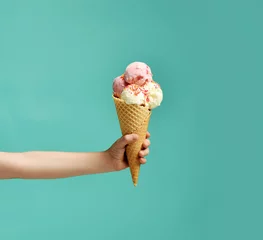 Fotobehang Baby kid hand holding big ice-cream in waffles cone on blue © Dmitry Lobanov
