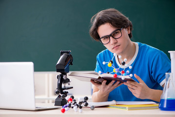 Young male student in the classroom 