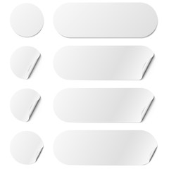 Set of white round and oval adhesive stickers with a folded edges, isolated on white background.