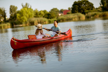 Fototapeta na wymiar Loving couple rowing on the lake