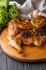 Roasted chiken on wooden board with sauce