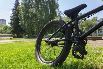 Sport bike parked on grass lawn in a city, public park. Bicycle rear wheel