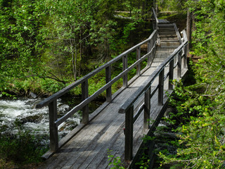 Wooden bridge over the turbulent northern river