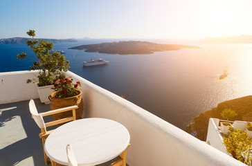 Fototapeta na wymiar Beautiful sunset at Santorini island, Greece. Two chairs on terrace with sea view