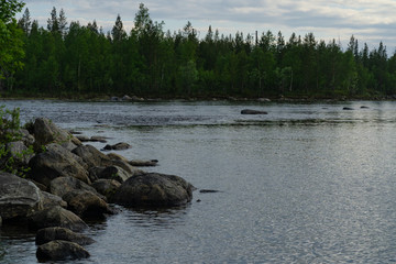 Sunlight through the clouds over the rocky northern lake