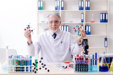 Old male chemist working in the lab 