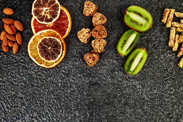 Obraz na płótnie Canvas Healthy snacks - variety oat granola bar, rice crips, almond, kiwi, dried orange
