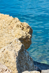                    Stones on a sea coast of Colimbari, Crete, Greece against a blue sea water. Copy space.           