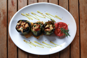 Filled aubergine with chicken on the table.