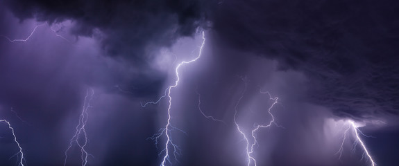 Fototapeta na wymiar Huge lightnings and heavy rain in dark stormy sky