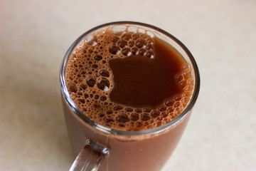 Beautiful coffee milk foam. Coffee with milk in a transparent glass on a dark background top view. Dark coffee in a transparent glass top view. Dark foamy coffee
