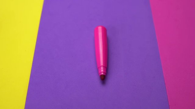 Set of a variety of non-permanent markers on colorful paper moves from right to left. Abstract minimal background with space for text. Back to school concept.