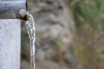 Taken in the woods. Natural spring water. Flowing through the pipe...