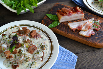 russian cuisine: closeup beef meat stewed with vegetables in ceramic pot on wooden background.