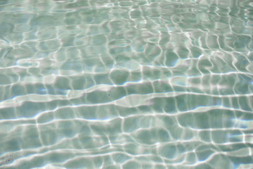 Fototapeta na wymiar blue water ripples in a summer swimming pool