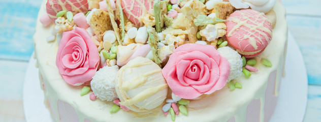 Pink cake with flowers and cupcakes on a white plate