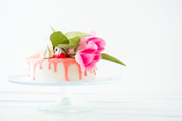 Bouquet of pink tulips on a white biscuit cake