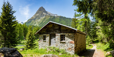 an abandoned cabin on the chemin des diligences in the valley of vallorcine in the french alps during spring showing distant mountains in the background