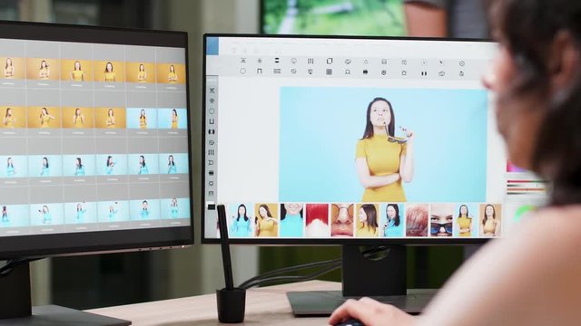 Female photographer uses professional editing software to work on her photos. In the background - creative media agency office