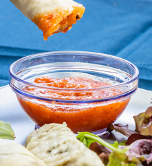 Dipping a sping roll into sweet chilli sauce. Calgary, alberta, Canada