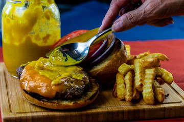 Spreading some homemade mustard on a juicy hamburger. Calgary, alberta, Canada
