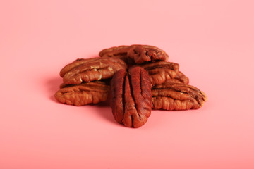pecan nuts on a pink background. creative minimalist style. healthy food