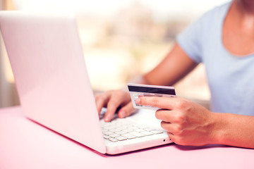 Woman holds credit card and makes online payment. Online shopping concept