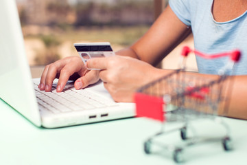 Woman holds credit card and makes online payment. Online shopping concept