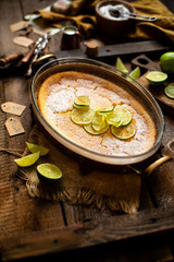 Homemade casserole, pudding, cheesecake, tart, pie or mousse with lime on top in glass baking dish 