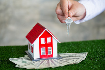 Your new house, real estate agent holding house key to his client after signing contract agreement in office,concept for real estate, renting property