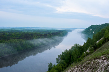 Obraz premium dawn on river. fog on the river. overcast sky