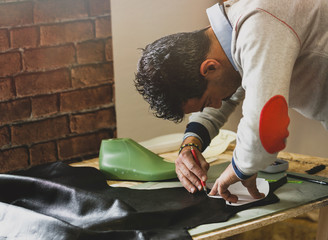 Shoe designer working with leather.
