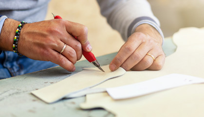 Shoe designer working with leather.