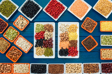Multicolor dried legumes in container flay lay on blue plank for background, Different dry bean for eating healthy, diet and healthy lifestyle, Collection of dried legumes organic for cooking