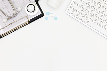 Stethoscope, Top view of doctor's desk table, above view doctor work tools on white, Stethoscope, laptop, eyeglass and medical drug on white background, medical doctor desk concept.