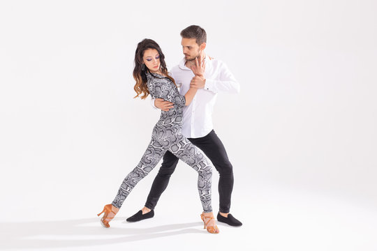 Social dance concept - Active happy adults dancing bachata or salsa together over white background with copy space