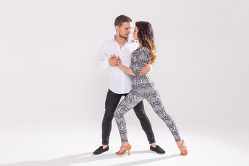Social dance, bachata, kizomba, zouk, tango concept - Man hugs woman while dancing over white...