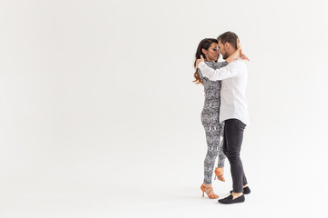 Social dance, kizomba, tango, salsa, people concept - beautiful couple dancing bachata on white...
